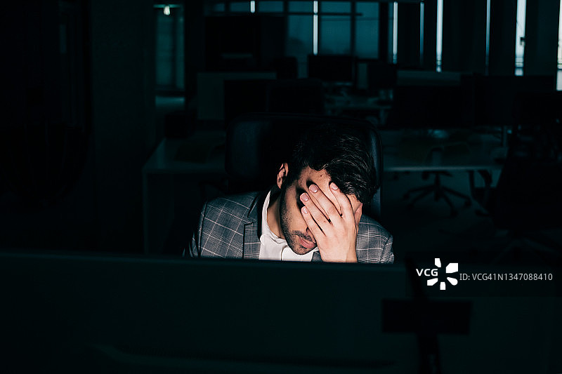 年轻商人晚上工作感到疲惫图片素材