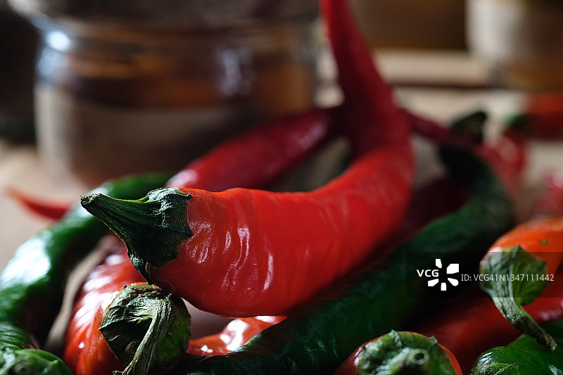 木质背景或厨房桌子上成熟和未成熟的红绿色辣椒，种植有机农产品图片素材