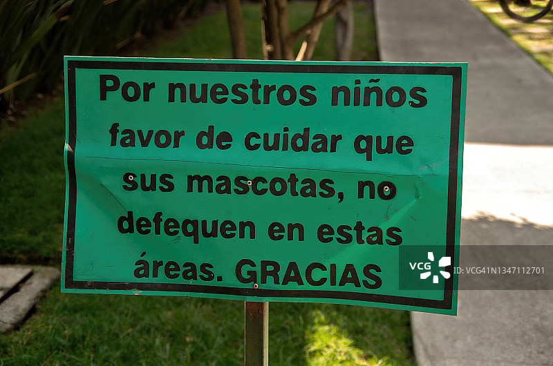 住宅楼草坪上的西班牙语标志，要求业主不要让宠物在草坪上排便图片素材