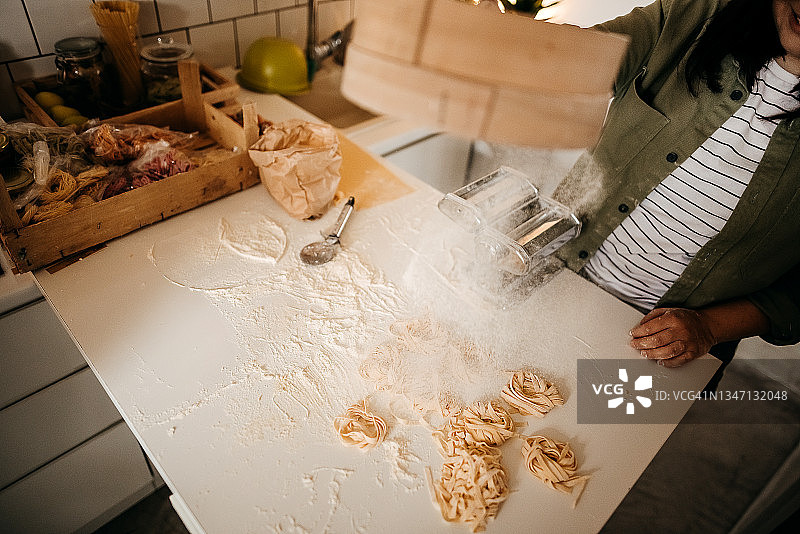 在厨房制作自制意大利面的年轻女人图片素材