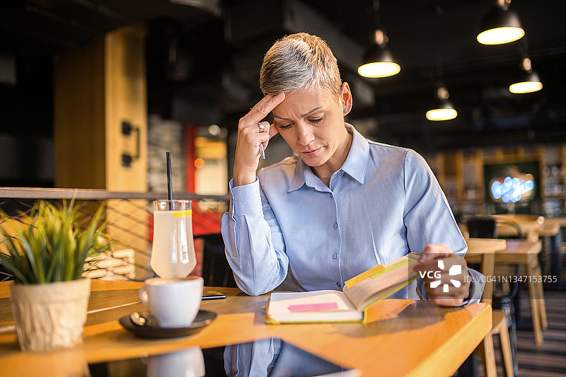 在咖啡店遇到问题并沉思的过度劳累的女商人图片素材