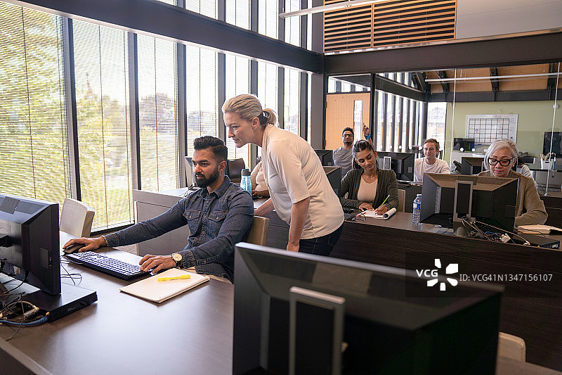 老师俯身帮助学生图片素材