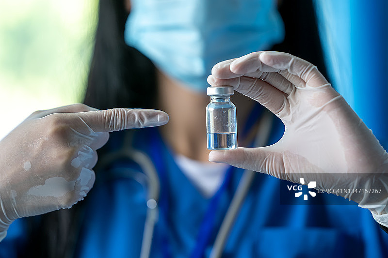 医生手持新冠疫苗第三剂图片素材