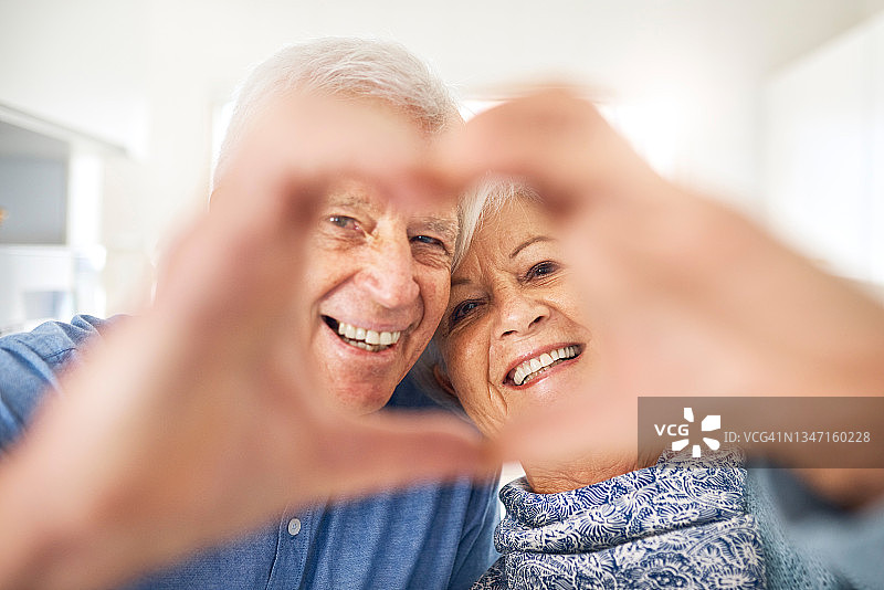 年长的夫妇在家中用手比心图片素材