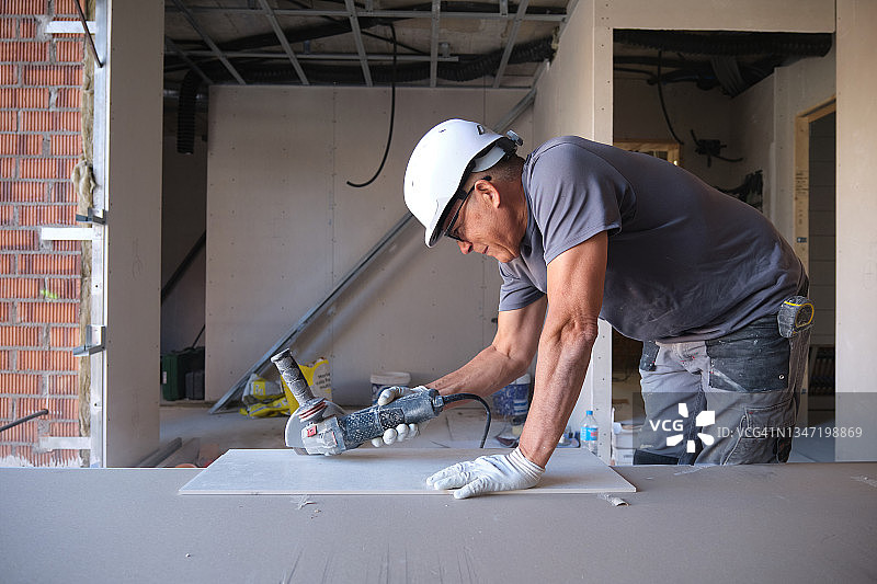 建筑工人使用角磨机切割瓷砖图片素材