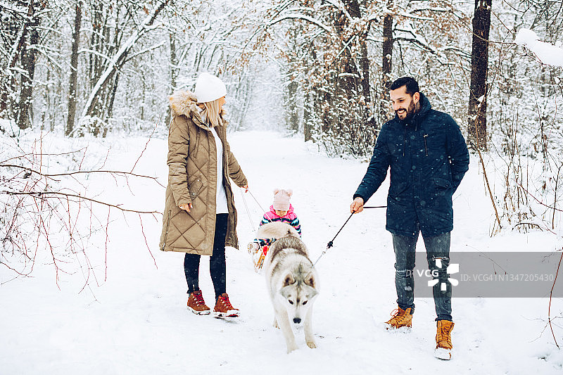 幸福家庭：雪天户外，孩子坐雪橇玩耍图片素材