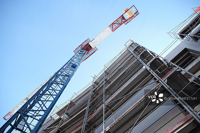 建筑工地上起重机工作的仰视角度图片素材