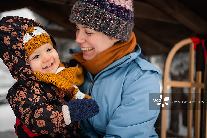 快乐的母亲和蹒跚学步的儿子享受冬季探险图片素材