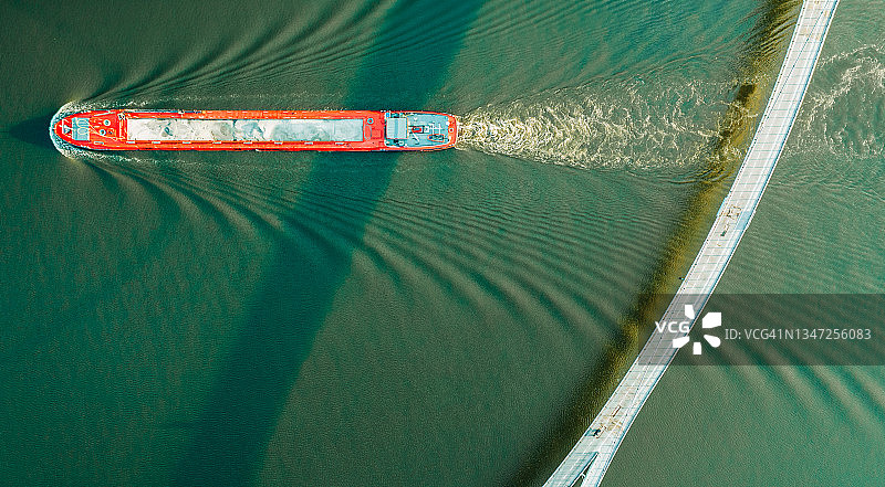 阿姆斯特丹内斯西奥桥下航行的商用驳船高视角照片图片素材
