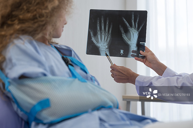 医生手持X光片与病人沟通图片素材