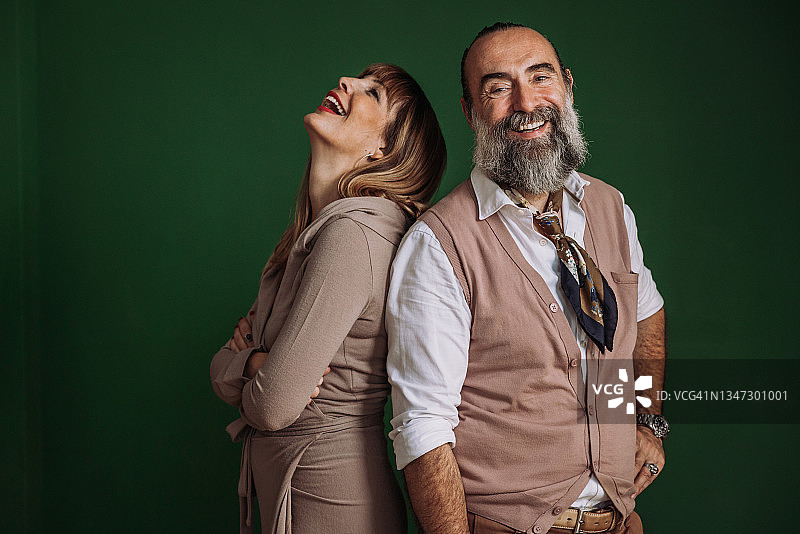 中年夫妇在绿墙前合影图片素材