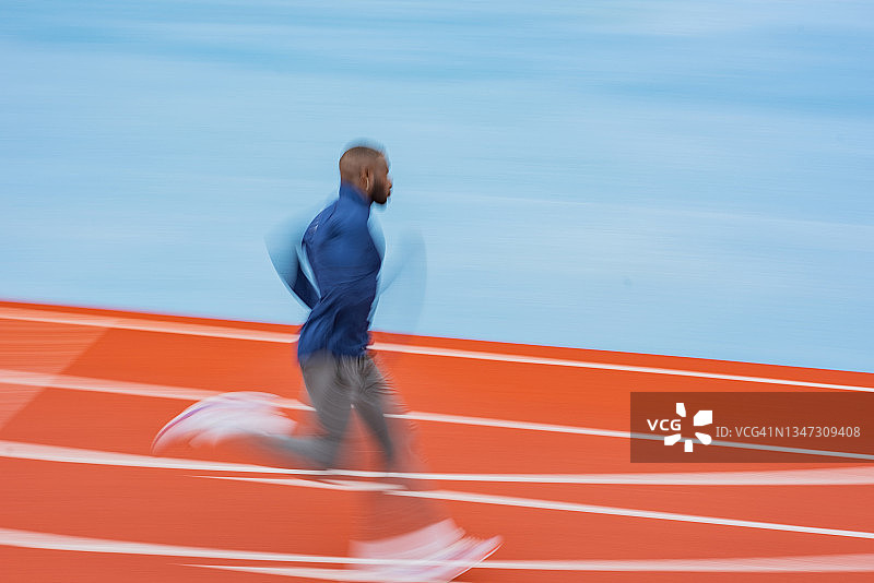 在赛道上跑步的年轻男运动员图片素材