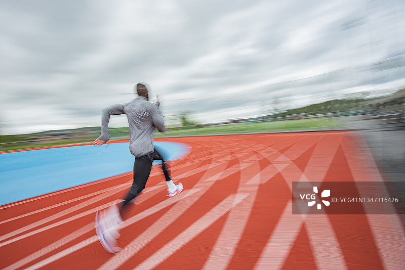 在赛道上跑步的年轻男运动员图片素材