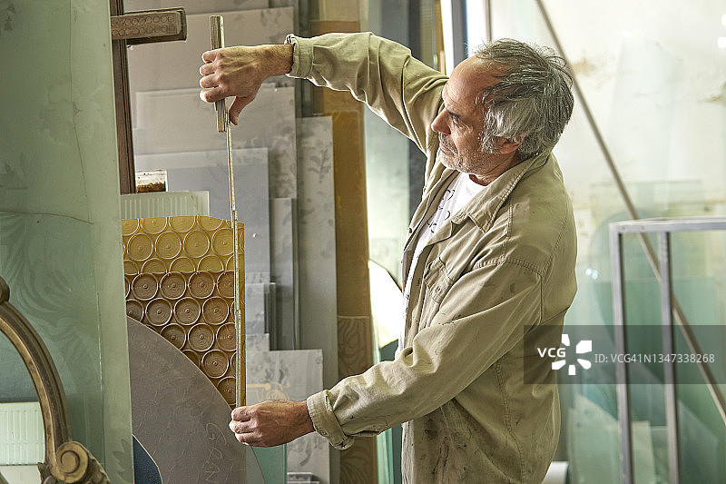 在玻璃车间测量的男人图片素材