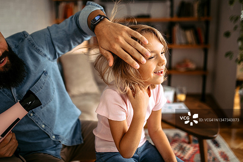 父亲在家为女儿吹干头发并做造型图片素材