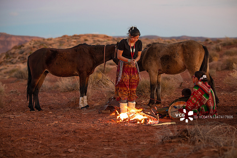 黄昏时分在篝火旁取暖的纳瓦霍族兄弟姐妹图片素材