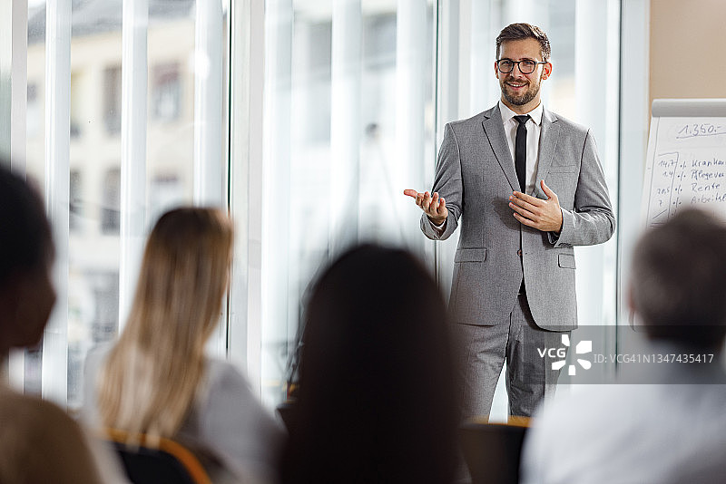 快乐的CEO在会议室向同事们发表演讲图片素材