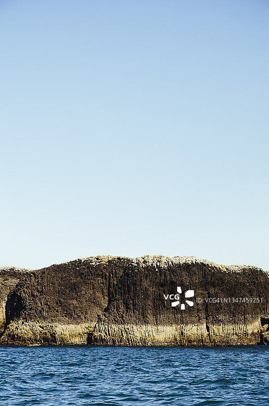 阳光明媚的新西兰岛屿湾火山岩地貌图片素材