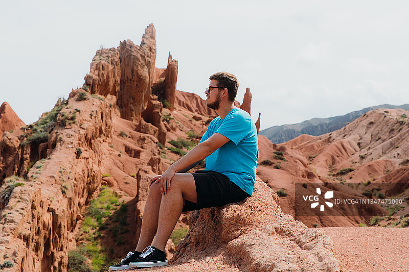 男人在吉尔吉斯斯坦峡谷中沉思自然图片素材