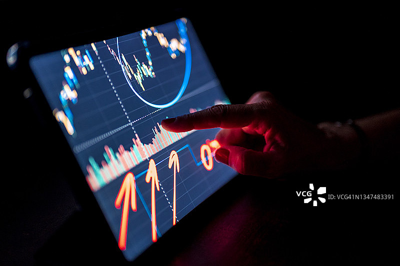 女商人指向平板电脑上的股市数据图片素材