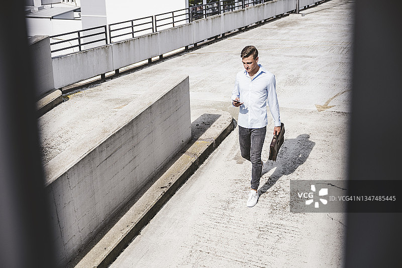 在屋顶上使用智能手机的商人图片素材