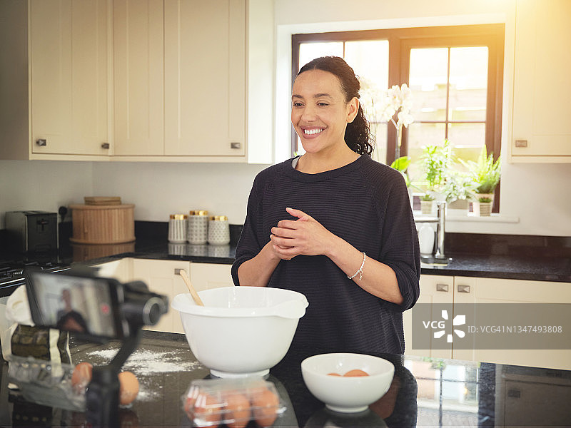 女人在厨房烘烤时用手机录像的照片图片素材