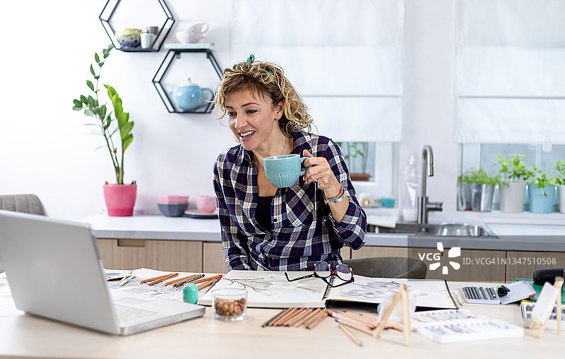 迷人的女人在笔记本上用铅笔画画图片素材