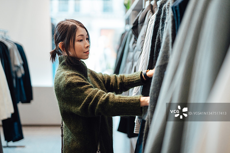 年轻女子在时装精品店购物图片素材