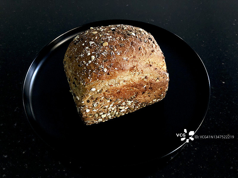 黑色背景黑色盘子里的蛋白质面包特写图片素材