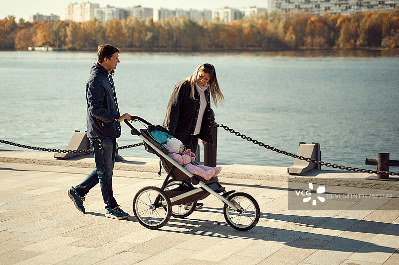 情侣在木板路上推着婴儿车同行图片素材