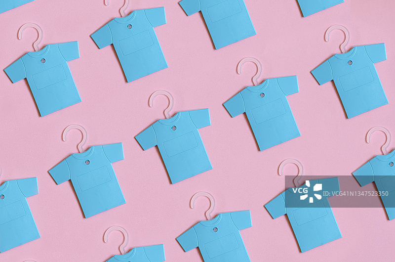 粉色背景上许多蓝色T恤的俯视图，带衣柜空气清新剂图片素材