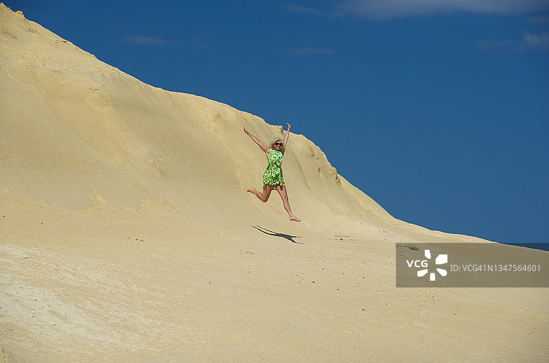 在马耳他戈佐岛石灰岩上跳跃的女人图片素材