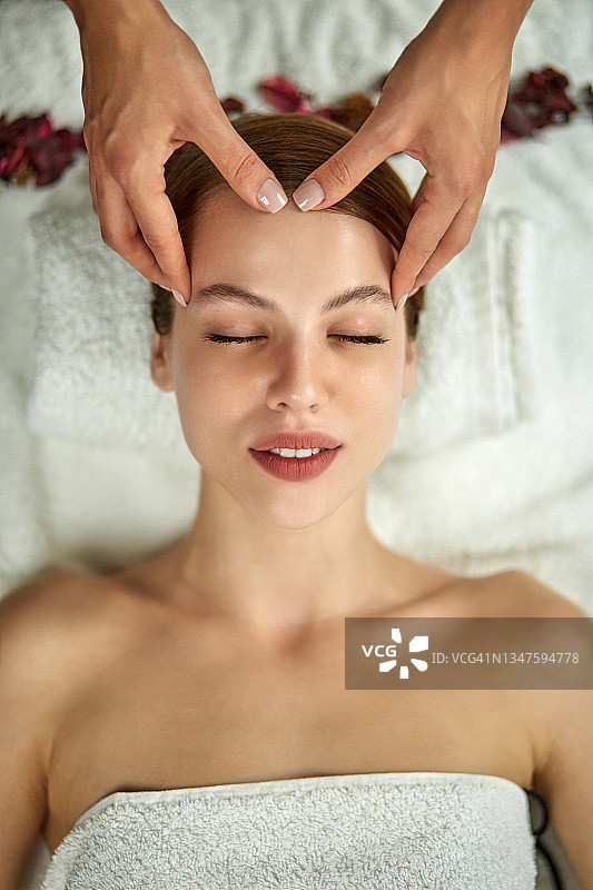 在健康水疗中心享受面部按摩的美丽女人图片素材