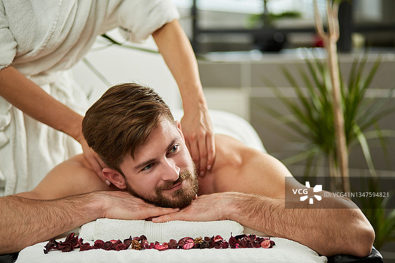 男人在养生会馆享受背部按摩图片素材