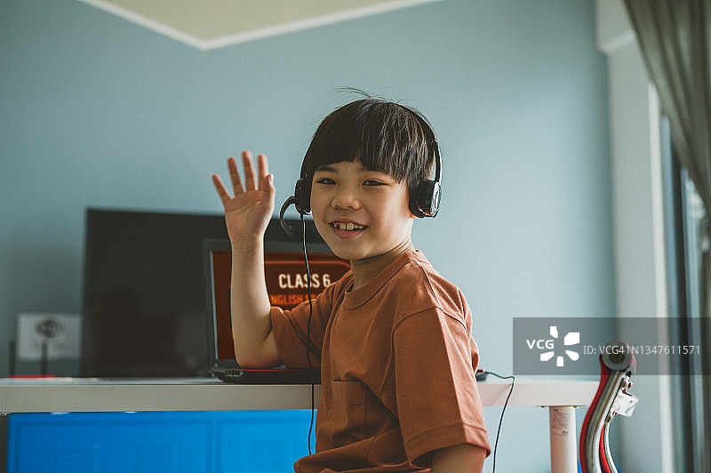 疫情期间在家用笔记本电脑学习的亚洲小男孩图片素材