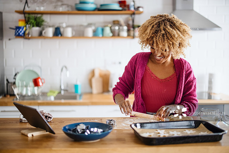 女人用擀面杖擀面团，烘烤圣诞节姜饼图片素材