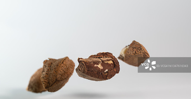 白色背景下半空飞舞的巴西坚果图片素材