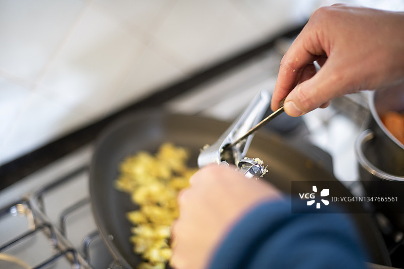 从压蒜器中取出姜的男人图片素材