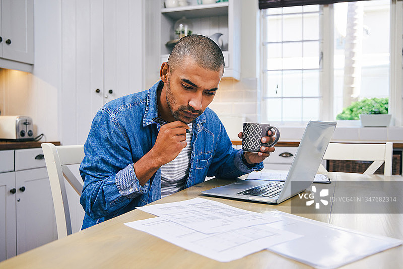 在家用笔记本电脑喝咖啡的年轻人图片素材