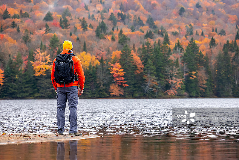 摄影师在沉思秋季的湖泊和彩色山脉，加拿大魁北克省翠湖山省立公园图片素材