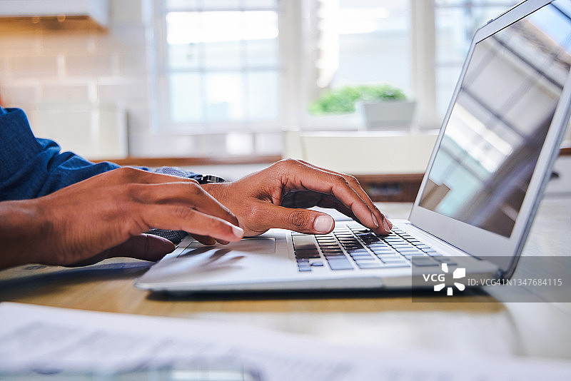 男子在家用笔记本电脑处理文件图片素材