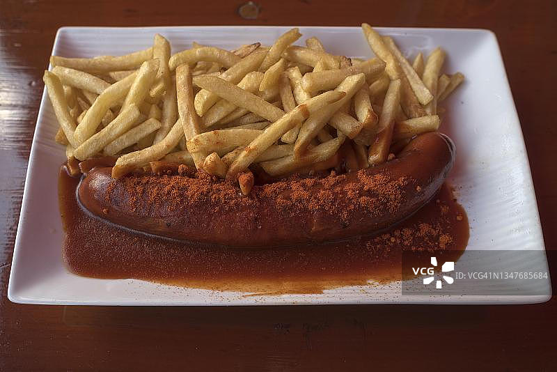 啤酒花园中的咖喱香肠配炸薯条，巴伐利亚，德国图片素材