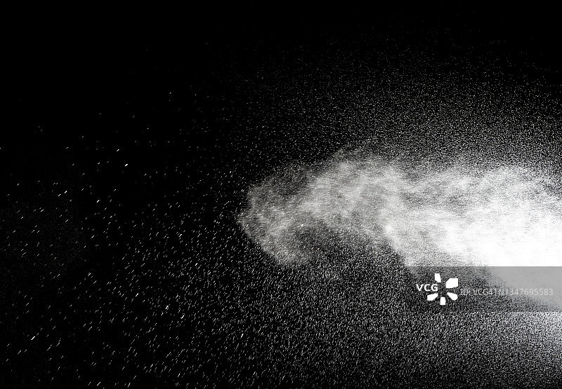 黑色背景下受压水流的水滴图片素材