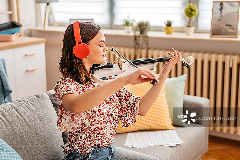 年轻的小提琴手在家练习演奏图片素材