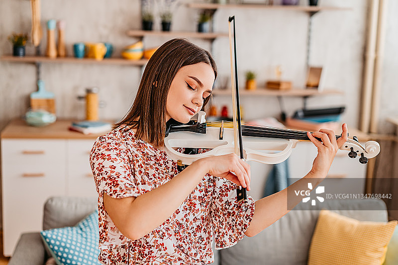 年轻的小提琴手在家练习演奏图片素材