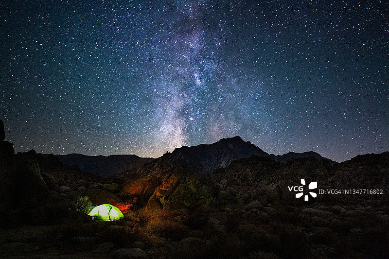 在银河系下独自在松树下露营图片素材