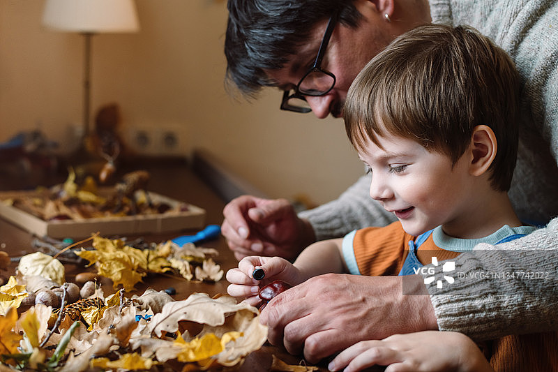 秋天，小男孩和父亲在家做手工图片素材