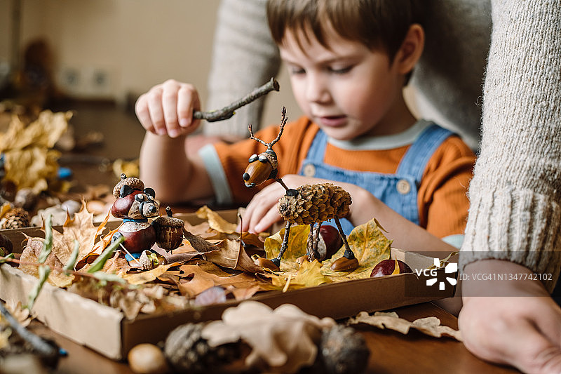 秋天，小男孩和父亲在家做手工图片素材