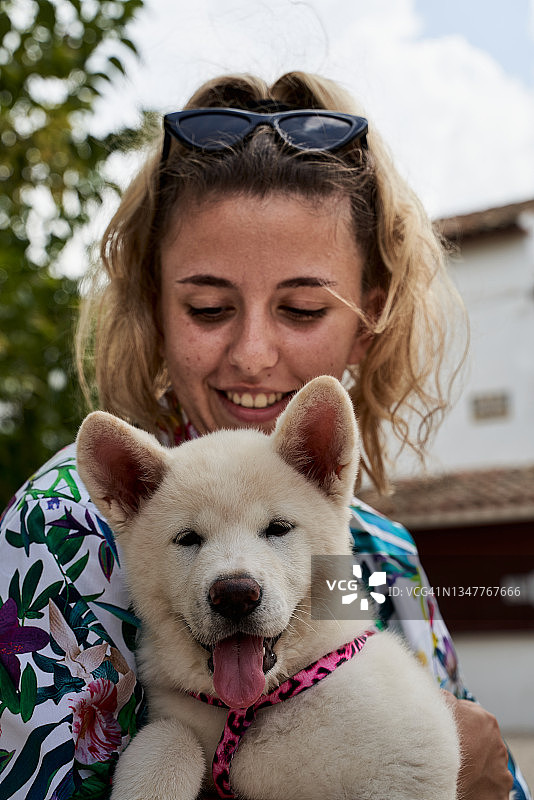 可爱的白人女孩抱着秋田犬宠物图片素材