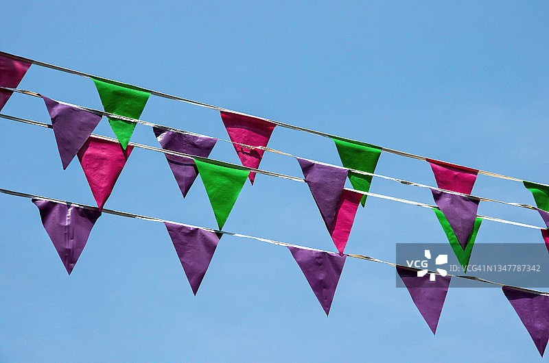 悬挂在蓝天下的塑料三角旗图片素材